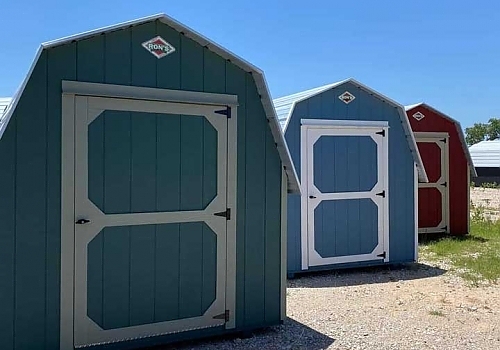 Green, blue and red white-trim sheds for sale.