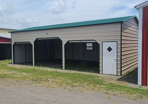 Cream colored green roof loafing shed in Beland, OK